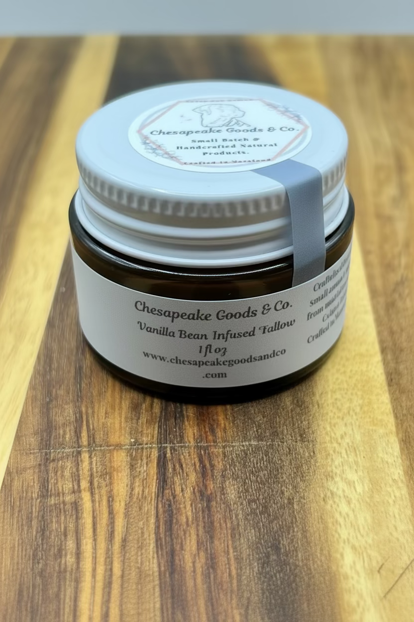 Chesapeake Goods & Co.'s 1 fl oz vanilla bean infused whipped tallow, a handcrafted natural skincare product, sits on a wooden surface.

